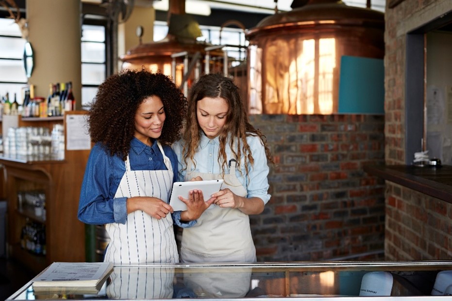 Two women looking at an iPad in a restaurant