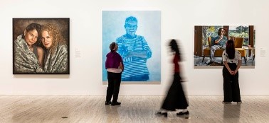 A group of women looking at artwork in an art gallery